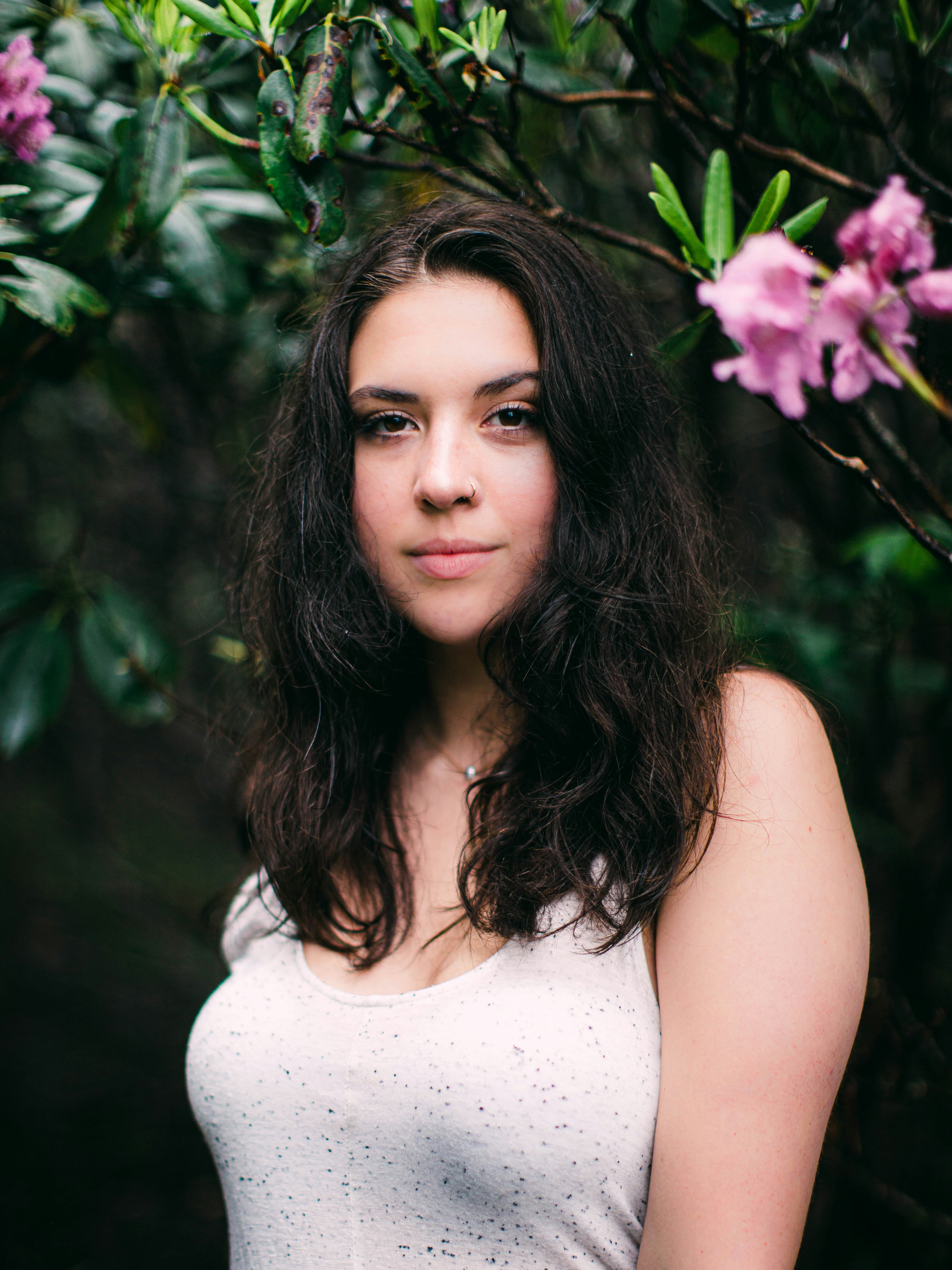 woman in white tank top with purple flower on her head